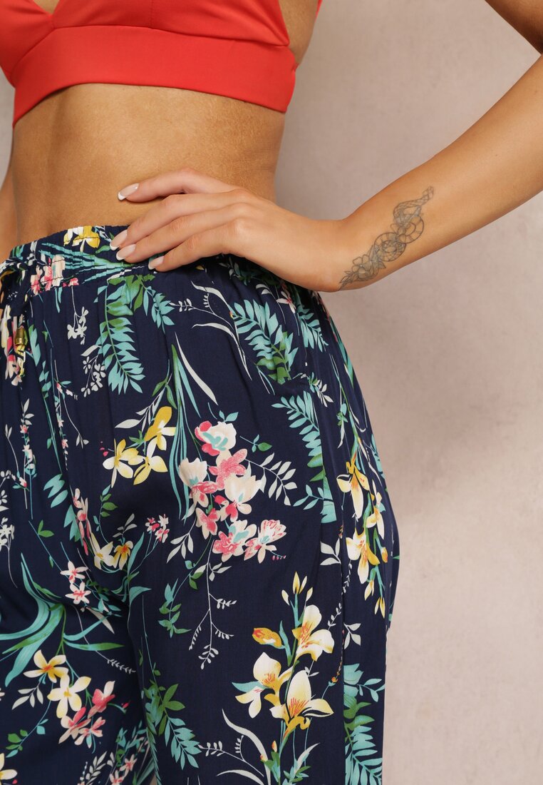 Pantaloni albaștri cu elastic în talie și la baza piciorului cu model floral Stesine